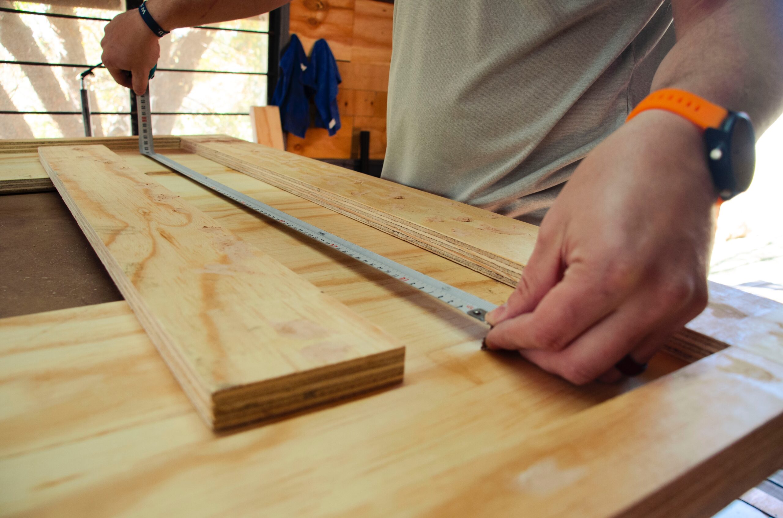 man measuring wood for carpentry